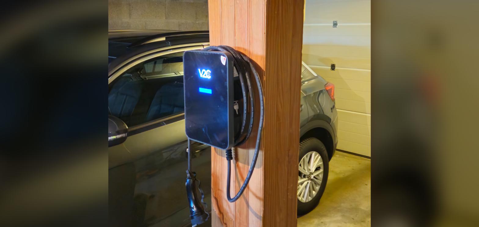 Borne de recharge installée sur un poteau dans un parking collectif de copropriété par United Borne